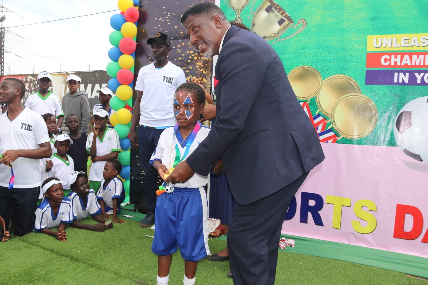 Train Up A Child Schools politician handing a gift to a student